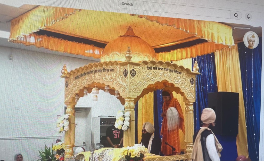 Guru Granth Sahib installed in the golden Palki Sahib under a yellow chanani