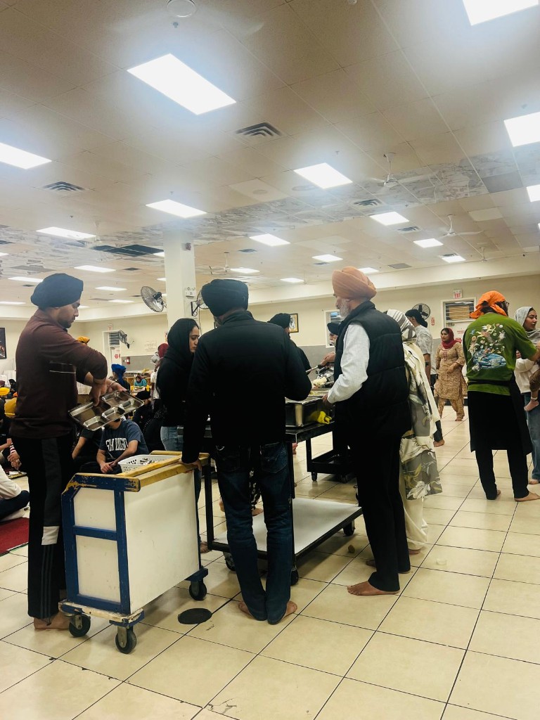 Volunteers preparing langar trays in the hall