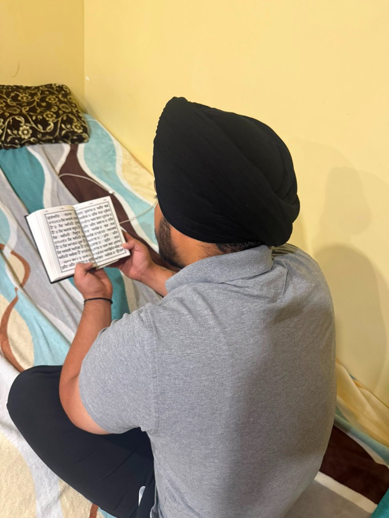 Devotee reading Gurbani from a Gutka Sahib in prayer